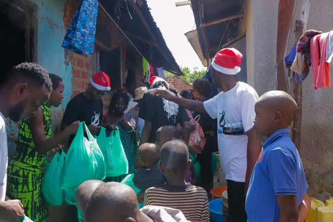 Volunteers in Santa hats handing Christmas hampers to families in a slum alley
