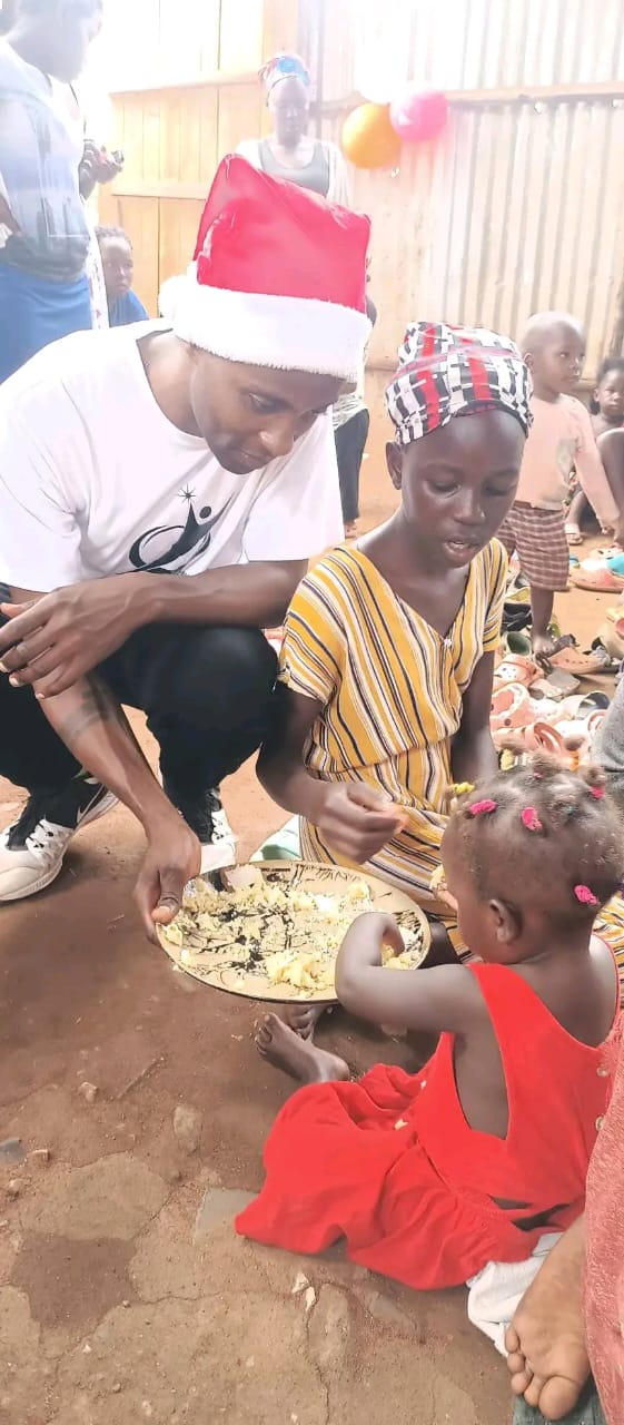 A volunteer and children sharing food during the 2024 Christmas celebration