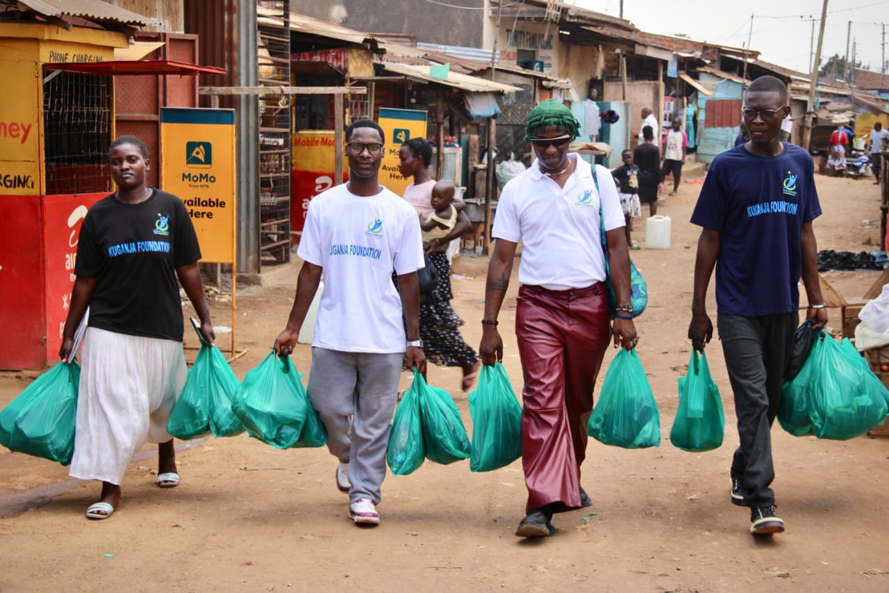 Kuganja Foundation volunteers carrying food supplies through the streets of Namuwongo, Kampala