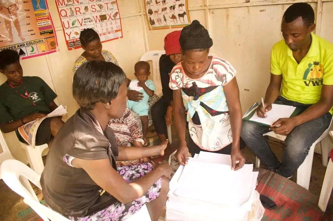 A woman reviewing schoolbook pages during a skills training session